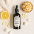 Brume Végétale Citron Meringué d’Atelier Louis, flacon verre ambré 100 ml, entouré de citrons frais et d’une tarte au citron meringué